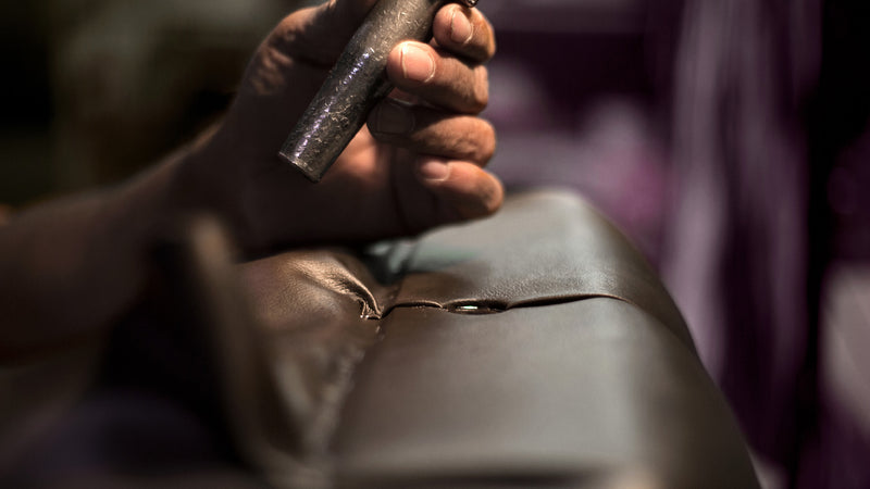 Hand-tufting the leather seat of a Jansen Artist Bench in the U.S.